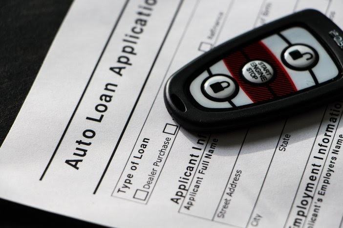 Photo of auto loan paperwork and car keys