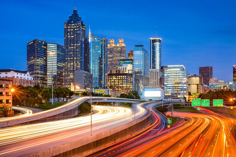 Long-exposure photo of city skyline with heavy car traffic