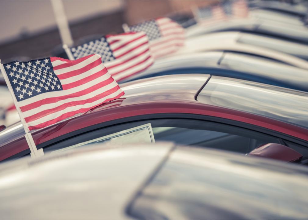 Photo of small american flags on a line of cars