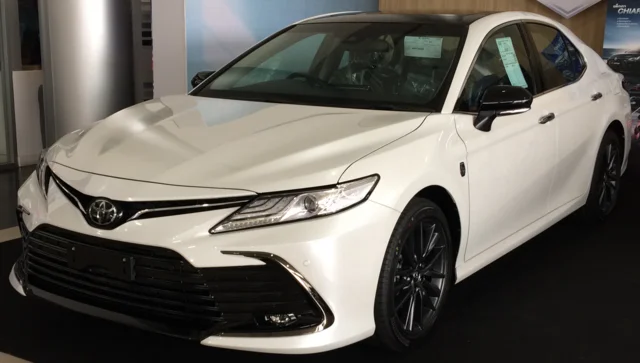 White 2022 Toyota Camry in a showroom