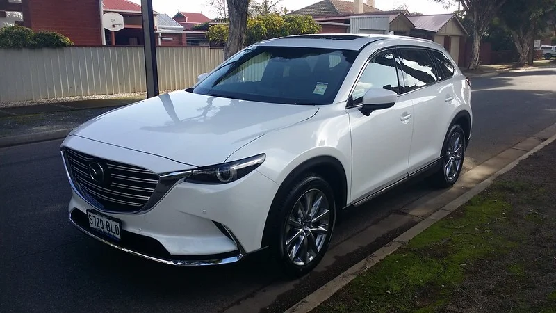 White Mazda CX-9 on a neighborhood street