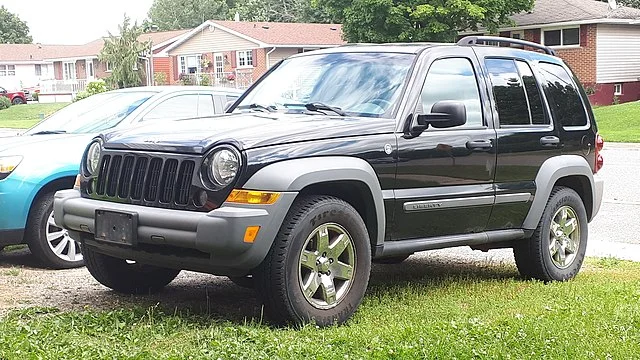 Black Jeep Liberty parked on grass