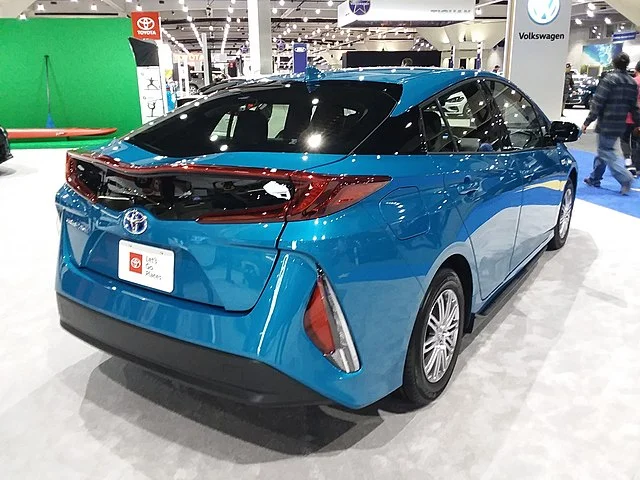 Rear view of a blue Toyota Prius Prime in a showroom