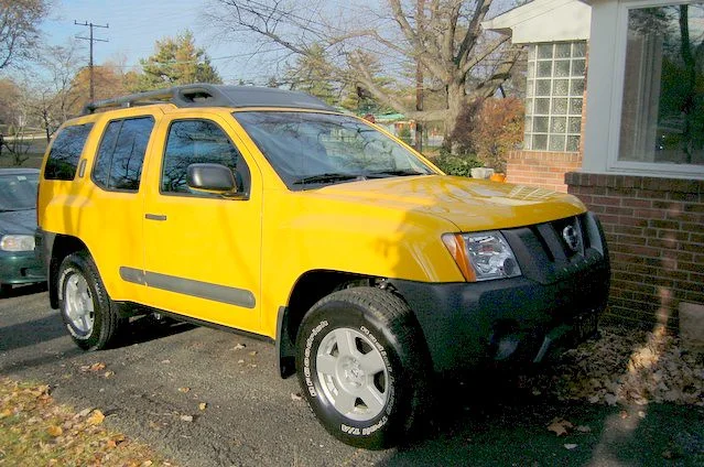 Yellow Nissan Xterra in a driveway