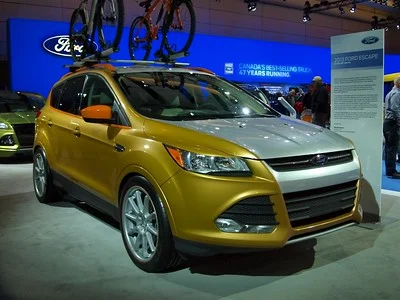 Silver and gold 2013 Ford Escape in a showroom