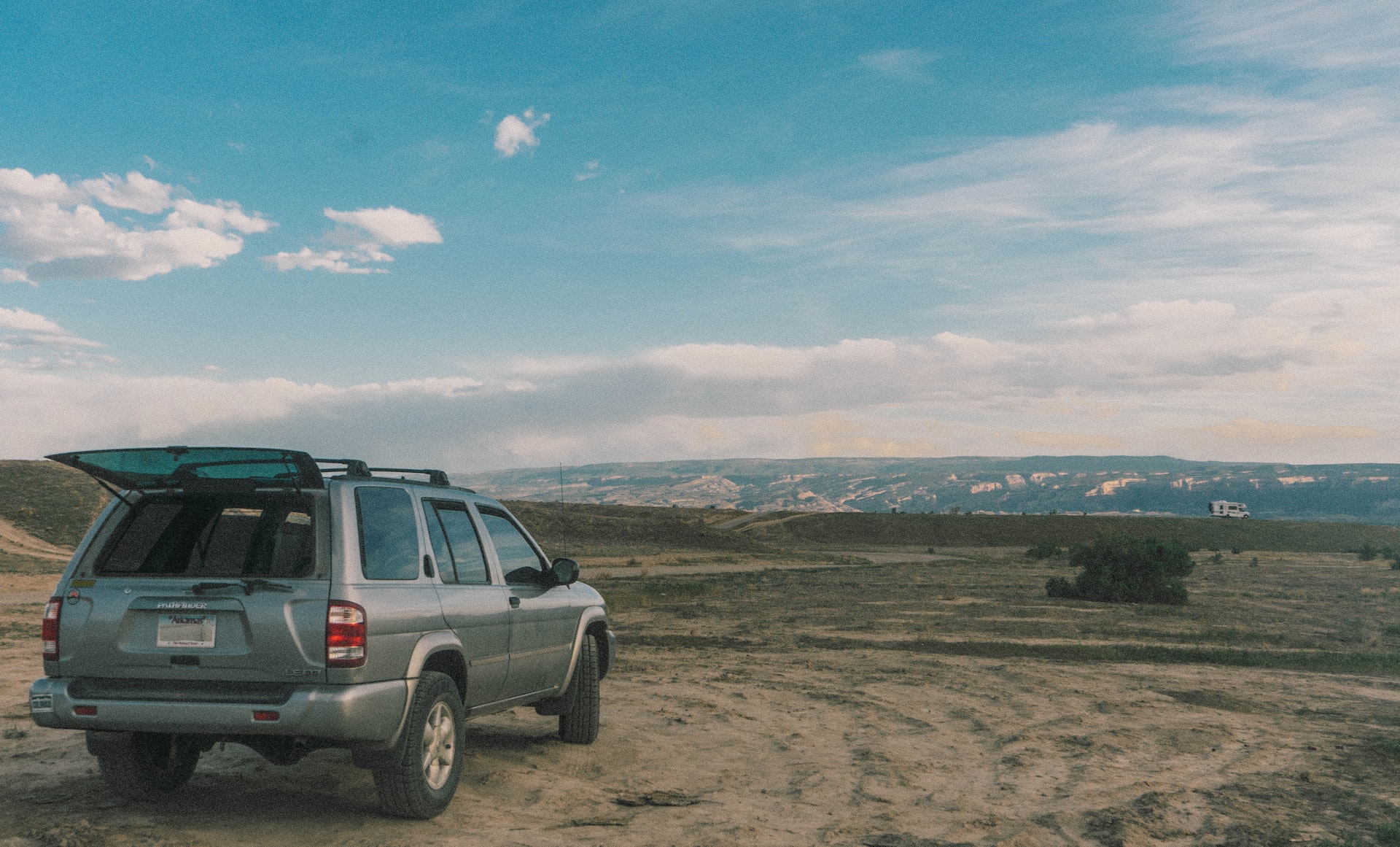 grey nissan pathfinder in a field