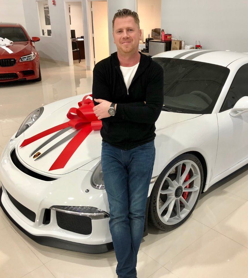 Photo of Auto Imports Miami founder posing with a Porsche