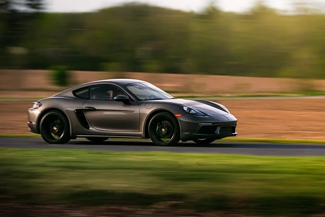 Porsche driving fast down a country road