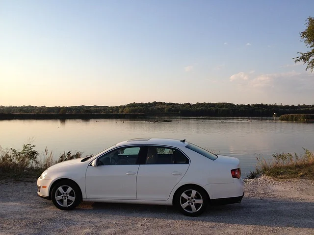 White Volkswagen Jetta parked by a lake