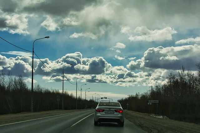 Kia Rio on a road with clouds