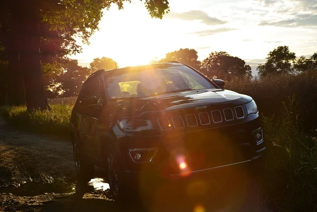 Jeep Compass driving in a field at sunset