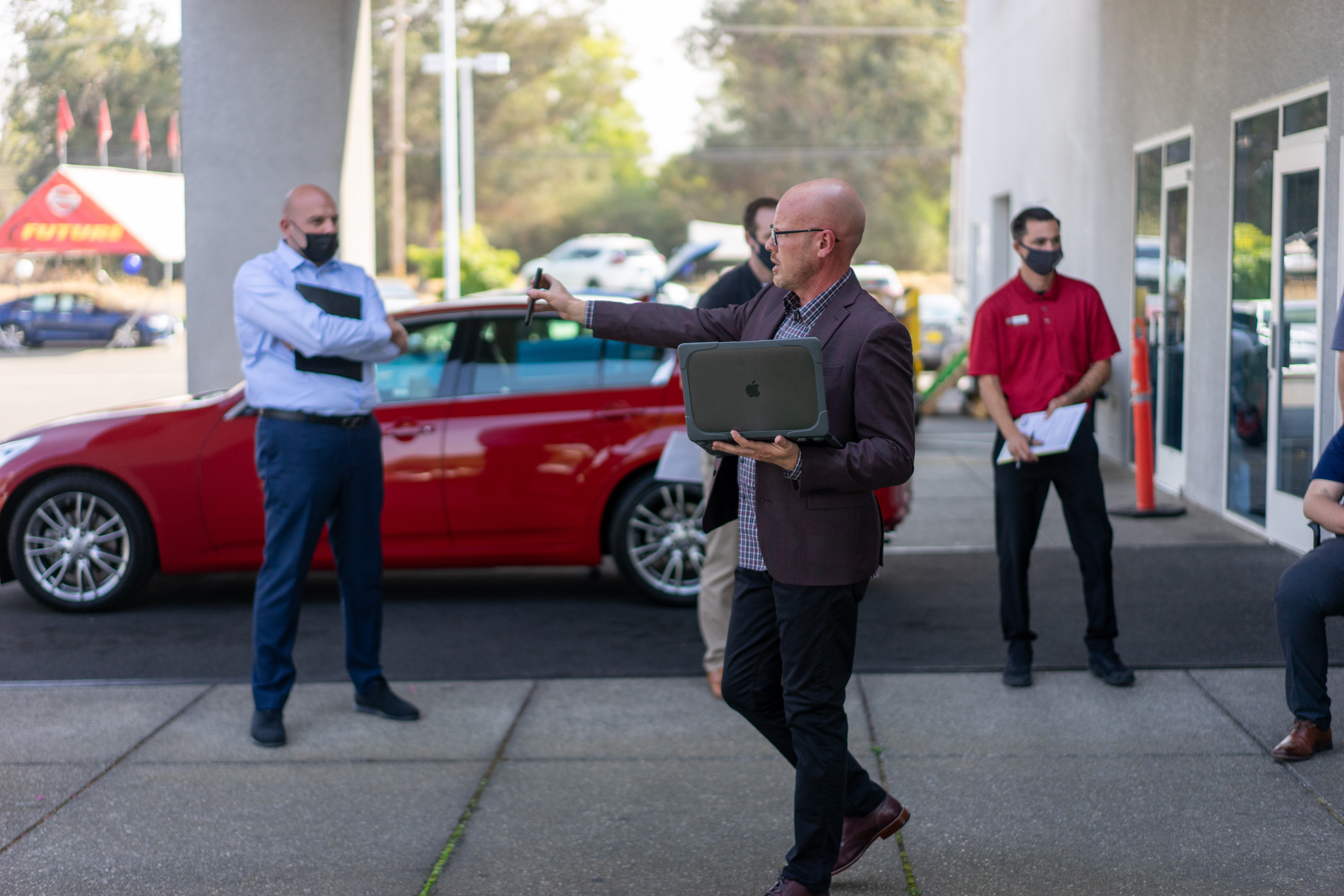 man outside car dealership selling car