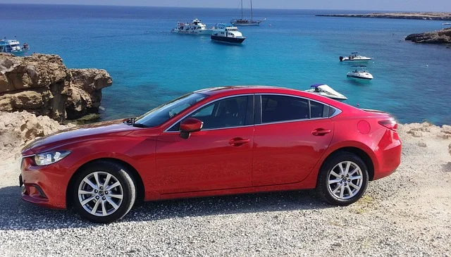 Red Mazda6 parked on a coastline