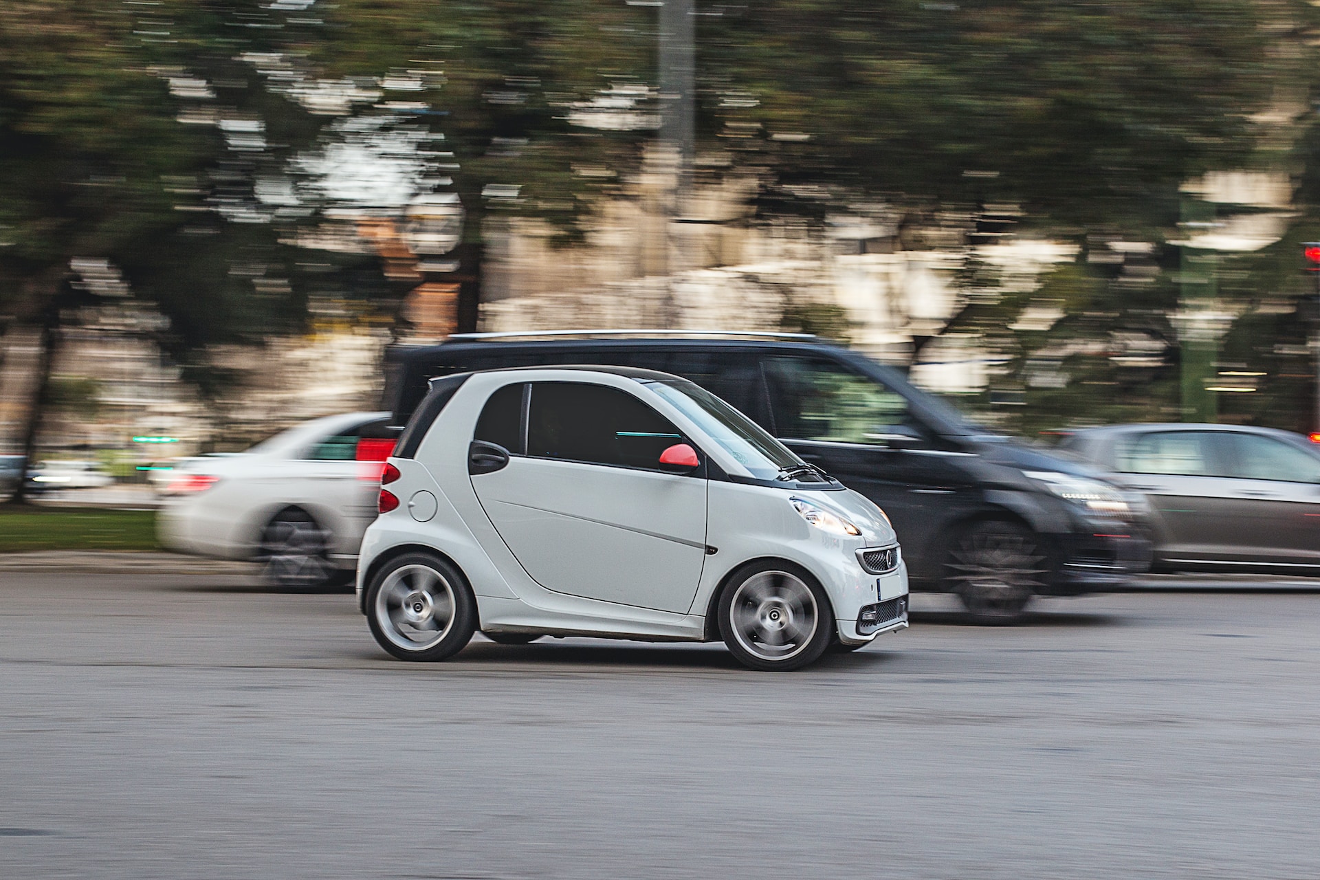 white smart car driving on a road
