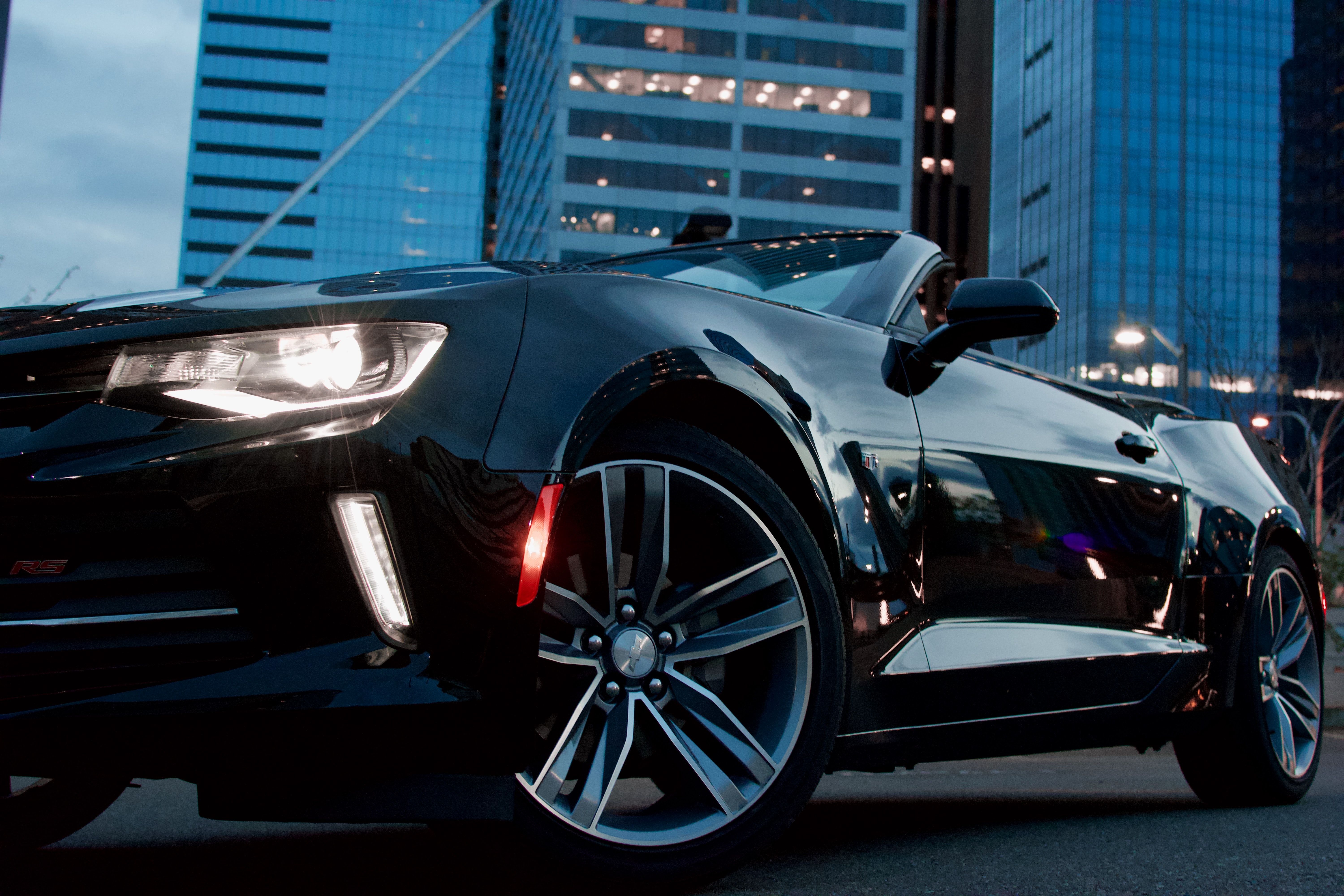shiny black sports car with a city backdrop