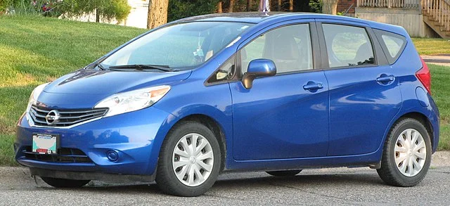 Blue Nissan Versa parked outside