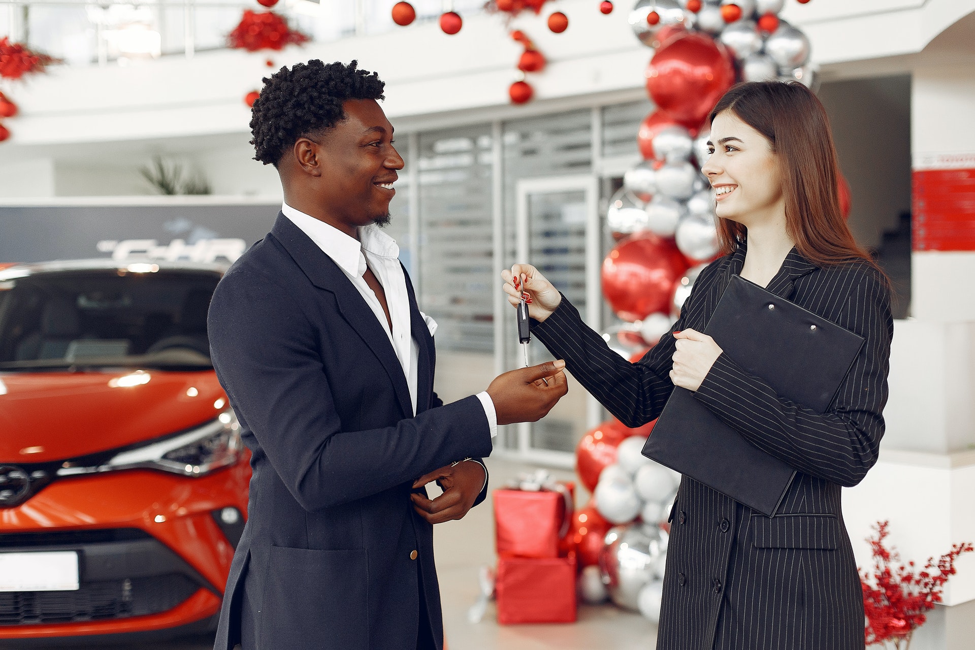 Photo of woman handing man car keys in dealership