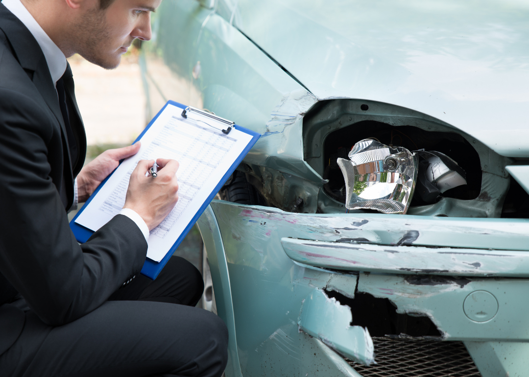 insurance adjustor assessing car damage