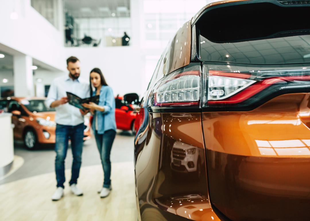 couple browsing vehicles in dealership show room